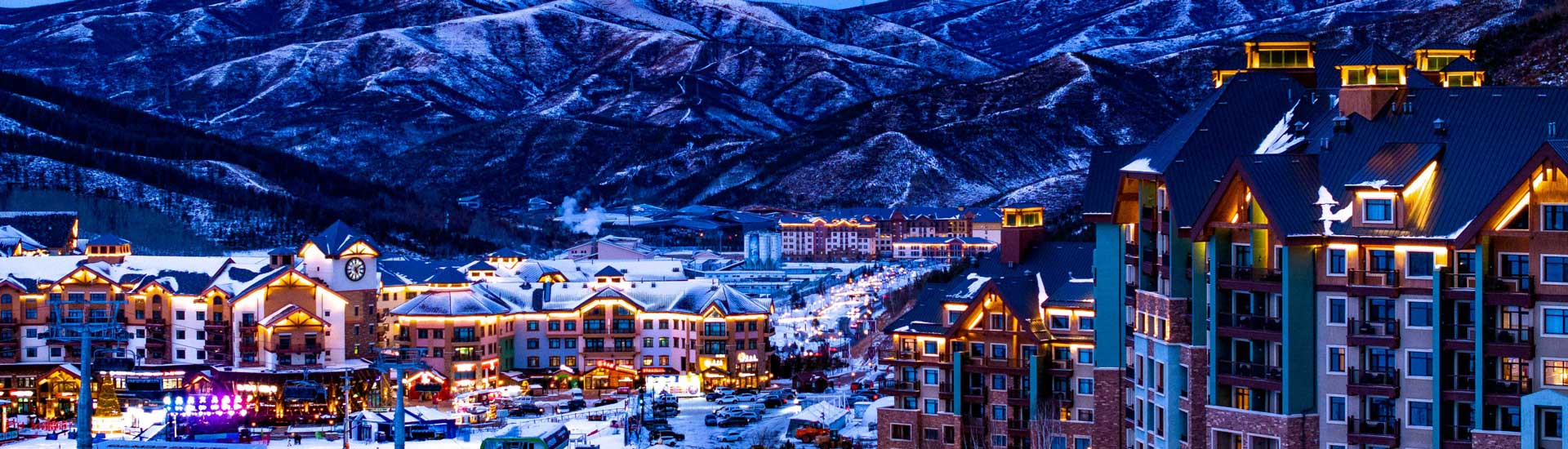 Thaiwoo ski resort village glowing at dusk beneath snow-covered mountains